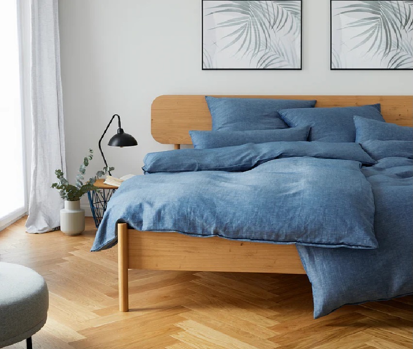 Bett mit blauer Halbleinen Bettwäsche